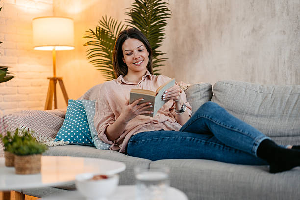 istock Young Woman Reading A Book At Home 2211961363