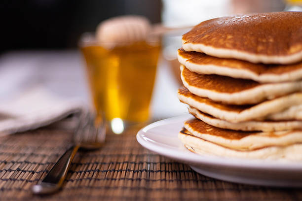 Pancakes of two sizes stacked on plates and placed on table