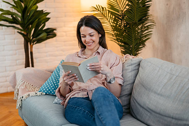 istock Young Woman Reading A Book At Home 2211962267