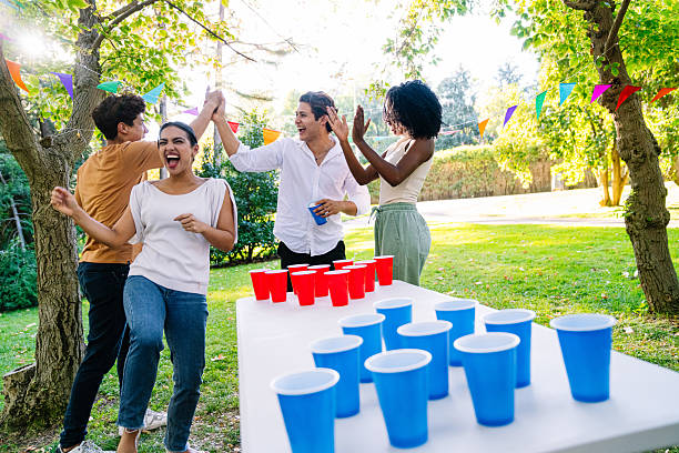 istock Young adults playing beer pong and celebrating in a park 2211962319