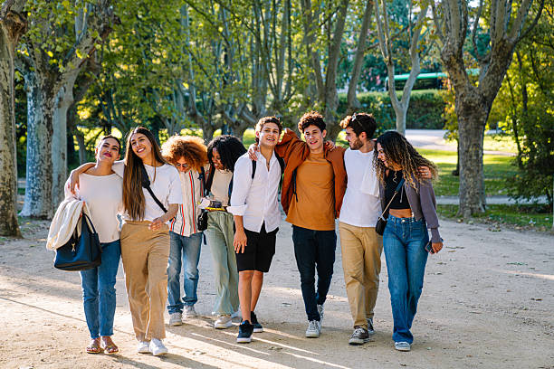 istock Happy multi-ethnic students walking together in a park 2211965840