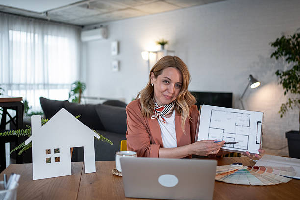 istock Interior designer showing house plan during a video call from home office 2211966738