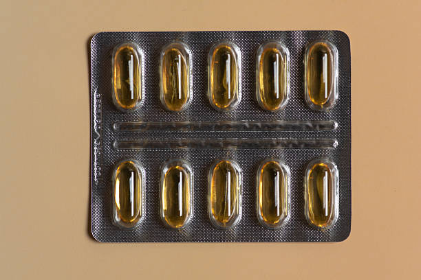 An organized blister pack filled with gleaming golden capsules elegantly displayed on a softly lit background. The image represents health, wellness, and the modern approach to self-care and nutritional supplementation.