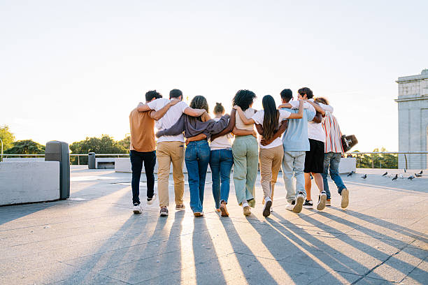 istock Group of students walking together on rooftop at sunset 2211975711