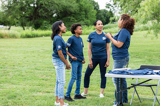 istock Community Outreach Volunteers Talking in Park 2211975774