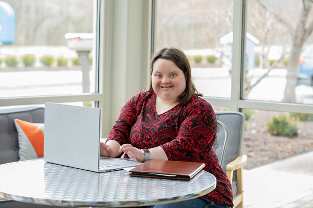 istock Confident Young Woman with Down Syndrome Working on Laptop 2211977319