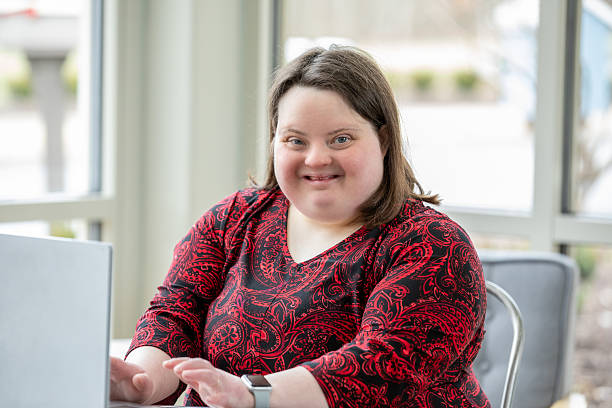 istock Professional Woman with Down Syndrome Uses Laptop at Work 2211977335