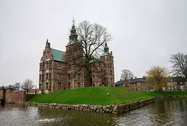 16 April 2018, Copenhagen, Denmark.\nRenaissance Rosenborg Castle Surrounded by Greenery and Reflective Moat