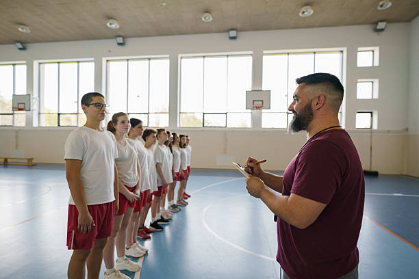 istock Trainer whit clipboard on sports training whit his team 2211980278