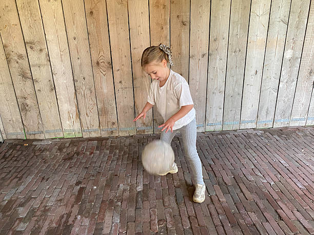 Girl with broken arm holding soccer ball