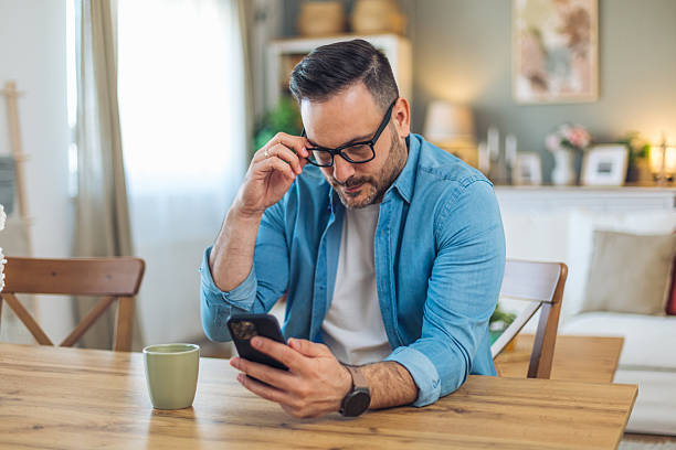 istock Focused man reading news on smartphone at home 2211982633