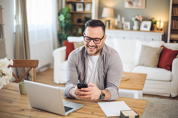 istock Smiling businessman using smartphone and working from home 2211983263