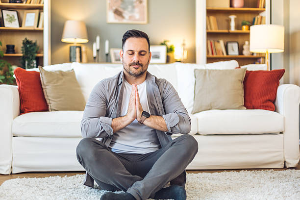 istock Serene man meditating in living room, finding inner peace and mindfulness 2211984764