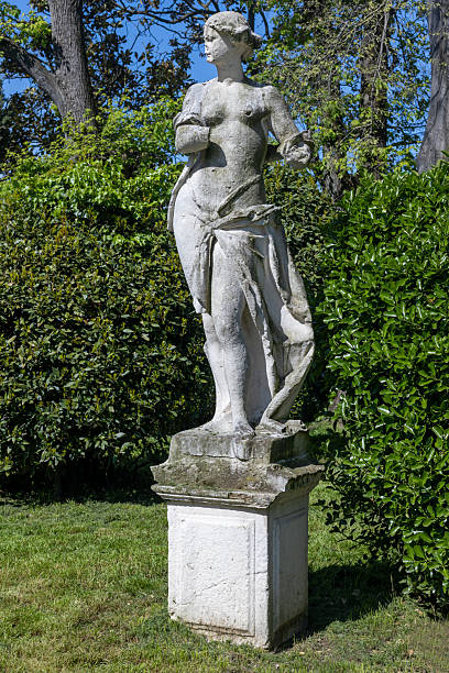 istock Weathered stone statue in green garden 2211986565