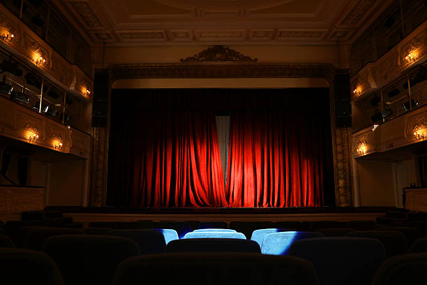 istock Elegant closed red curtains illuminated by spotlight in theatre 2211986930