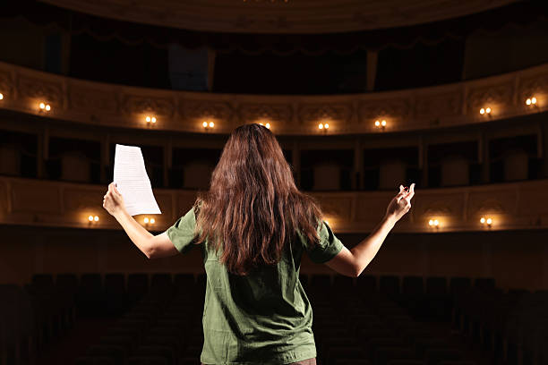 istock Professional actress rehearsing on stage in theatre, back view 2211986935
