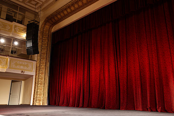 istock Elegant red curtains and spotlights in theatre 2211986995