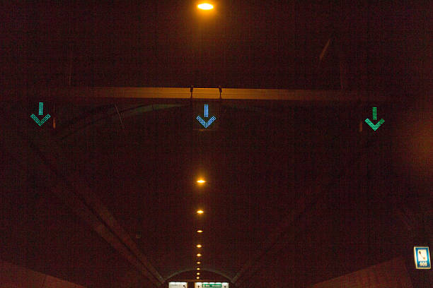 istock Illuminated Traffic Signs within Tunnel Displaying Green Arrows for Drivers 2211991415