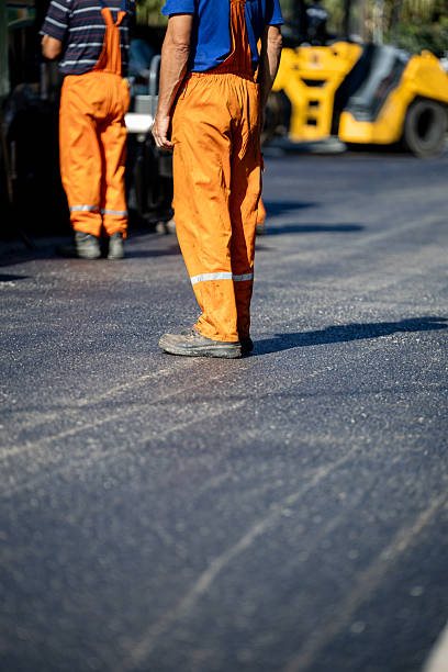 istock Workers in orange overalls engaged in road construction during daytime 2211991662