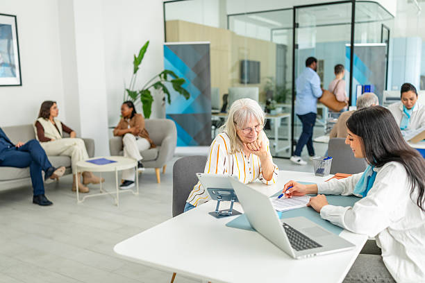 istock Meeting between financial advisor and clients in modern banking office setting with diverse individuals engaged in discussion 2211992500
