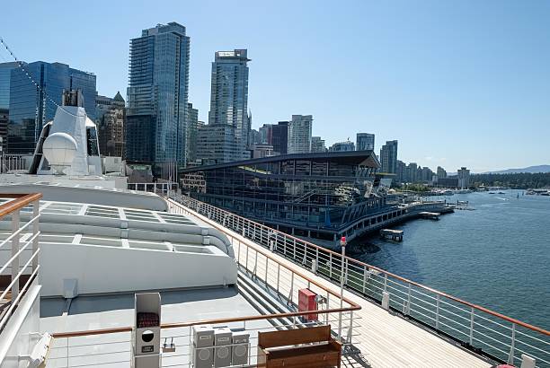 A cruise ship docked along Vancouver's urban waterfront with views of modern glass architecture and the city skyline, reflecting coastal tourism and harbor design.