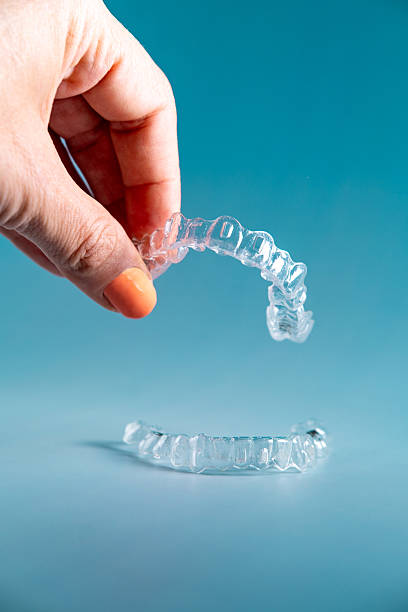 istock Woman's hand holding invisible aligners. 2211994166