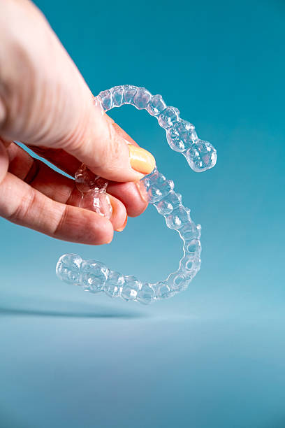 istock Woman's hand holding invisible aligners. 2211994177