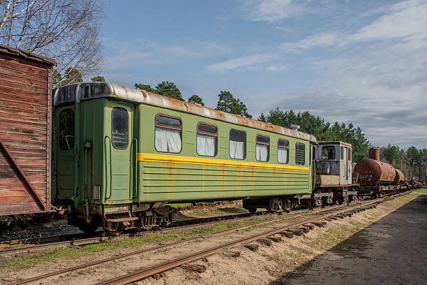 istock Green train car is parked on the tracks. The train car is old and rusty 2211997379