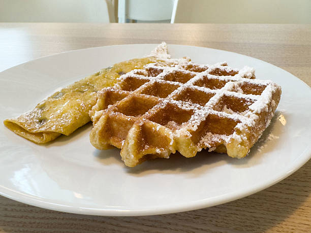 istock Delicious belgian waffle and crepe on white plate with powdered sugar 2211999403