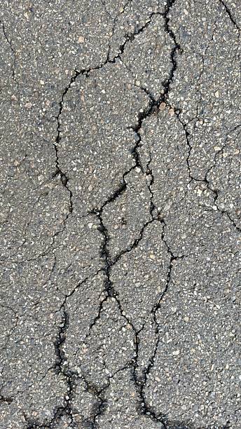 istock Cracked Asphalt Pavement Surface Texture – Road Damage Concept 2212008453
