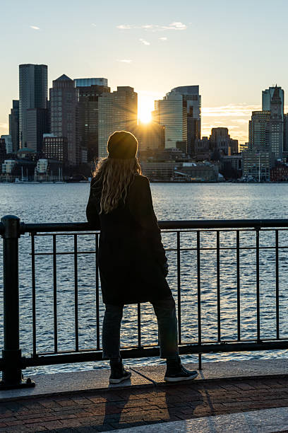 istock A woman looking at Boston skyline during a sunset. 2212015541
