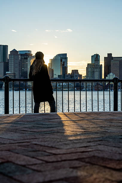 istock A woman looking at Boston skyline during a sunset. 2212015542