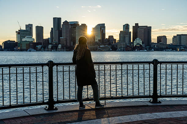 istock A woman looking at Boston skyline during a sunset. 2212015543
