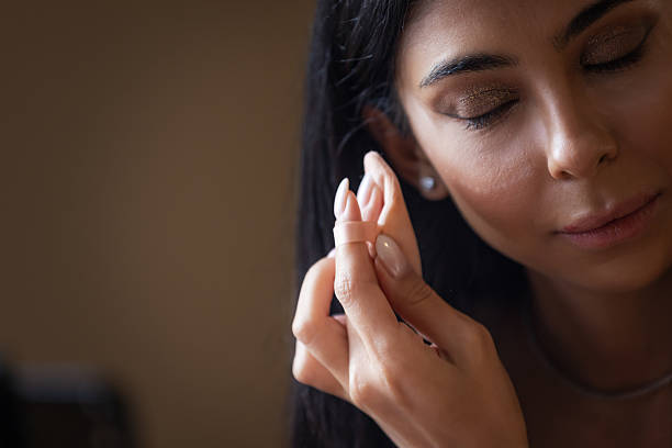 istock Young woman is applying make-up. 2212016000