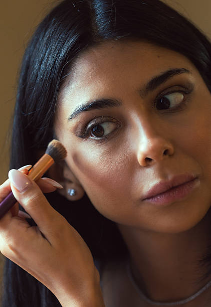 istock Young woman is applying make-up. 2212016519
