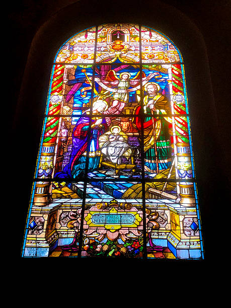 Colorful stained glass window in a gothic style shape inside the Matthias Church at the Holy Trinity Square in Budapest, Hungary 2022