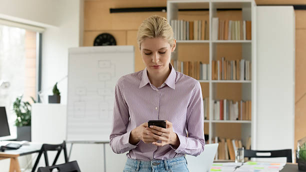 istock Focused millennial employee chatting online on smartphone 2212028917