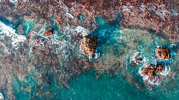 istock Blue waves hit rocky cliffs. perfect for summer scenes and nature backgrounds. 2212030258