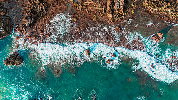 istock Summer coastline from above dramatic wave action on rocky cliff in aerial view. 2212030313
