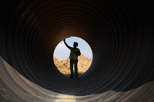 istock A Male Project engineer holds drawing work inside a huge pipe of an infrastructure project 2212036674