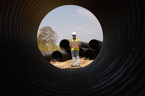istock A Male Project engineer holds drawing work inside a huge pipe of an infrastructure project 2212036690