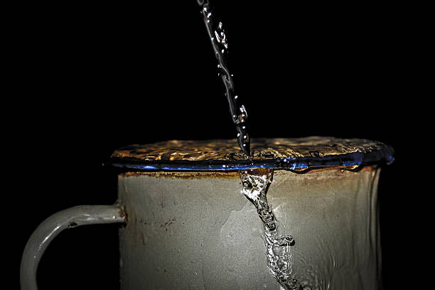 istock Spilled water falls into the enamel cup 2212039949