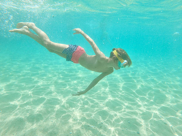 istock Young caucasian boy moving down underwater 2212039995