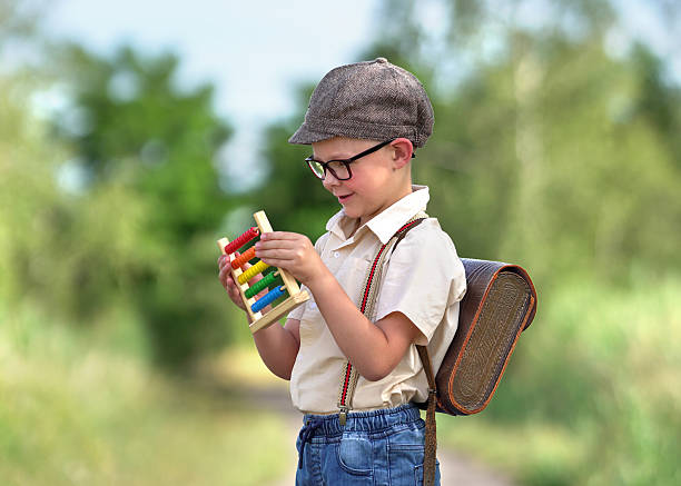 little boy is learning with the slide rule at first day at school
