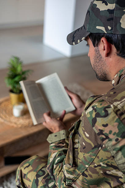 istock Soldier with post-traumatic stress disorder reading a book at home 2212051337