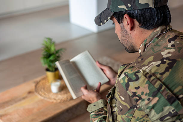 istock Depressed soldier reading a book at home, suffering from post-traumatic stress 2212052743