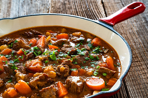istock Beef goulash with vegetables in frying pan on wooden table 2212054103