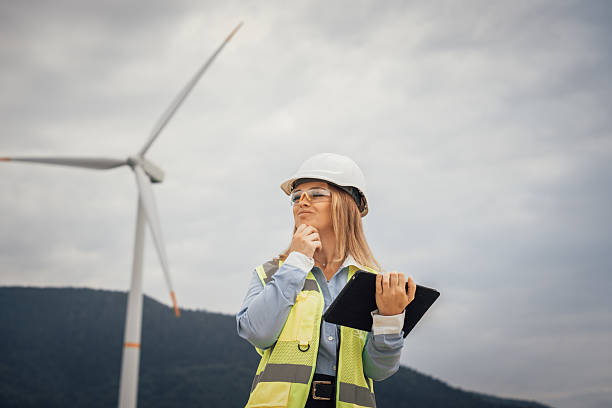 istock A Female Engineer Reflects on Innovative Renewable Energy Solutions at a Wind Farm, Surrounded by Nature and Tall Turbines, Using Her Tablet to Collaborate with Her Team and Share Ideas 2212055513