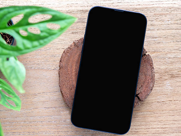 istock A minimalist flat-lay composition featuring a modern smartphone with a blank black screen over a wooden background. Concept online shopping, blog, logo, product, and social media. 2212059883
