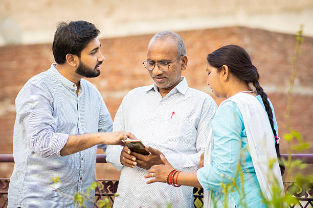 istock Happy young man talking and spending quality time with his middle aged Indian parents on rooftop. 2212060577